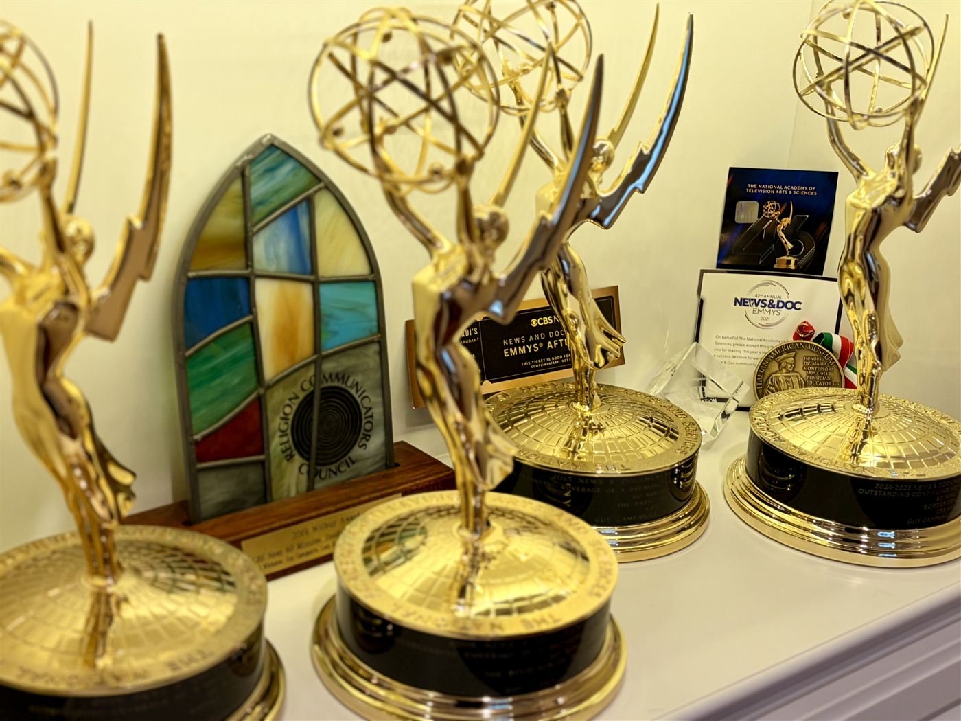 A shelf of Guy Campanile's national Emmy Award statuettes